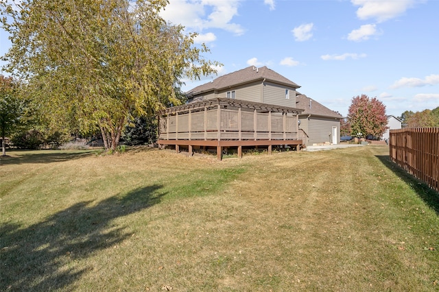 rear view of property featuring a deck and a lawn