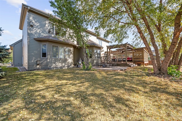 rear view of house with a patio, a yard, and a wooden deck