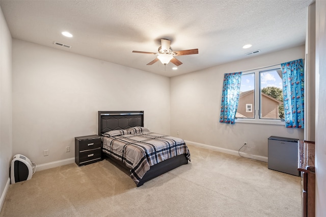 bedroom with light carpet, a textured ceiling, and ceiling fan