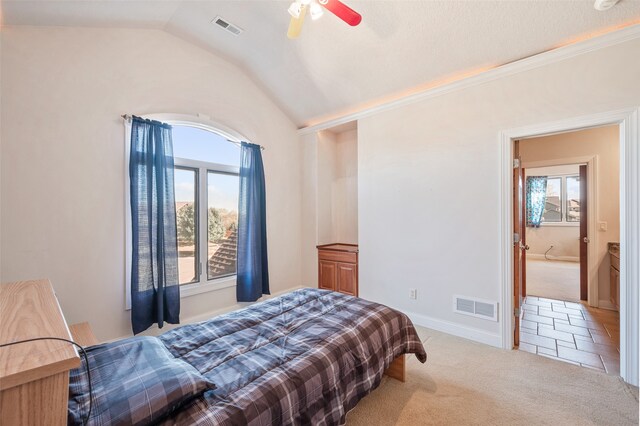 carpeted bedroom featuring multiple windows, vaulted ceiling, and ceiling fan