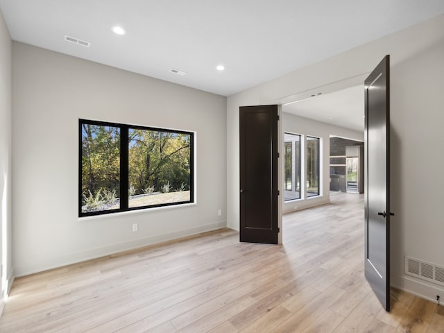 unfurnished room featuring french doors and light wood-type flooring