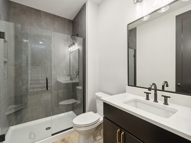 bathroom featuring hardwood / wood-style flooring, a shower with door, vanity, and toilet