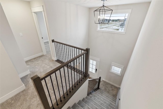 staircase featuring carpet flooring and an inviting chandelier