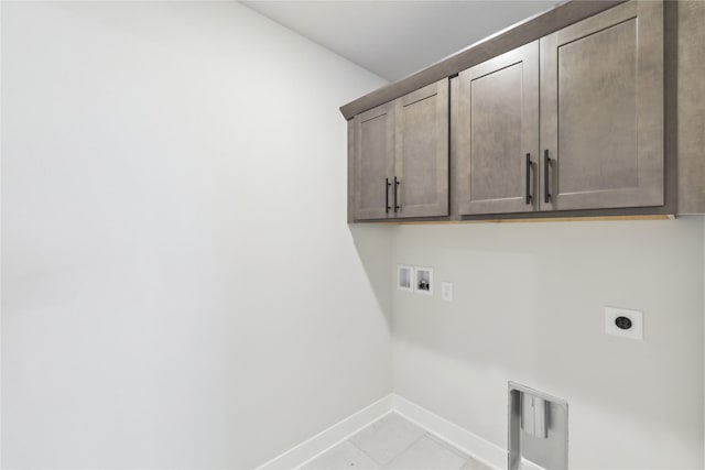 clothes washing area featuring cabinets, washer hookup, electric dryer hookup, and light tile patterned flooring