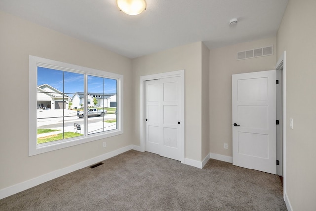 unfurnished bedroom featuring a closet and light colored carpet