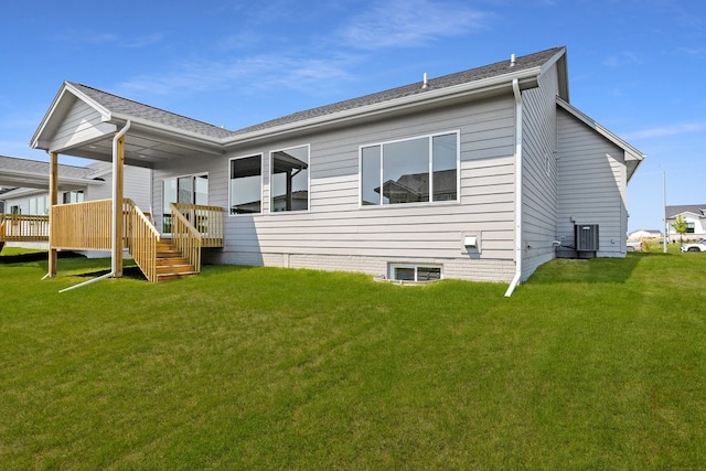 rear view of property featuring a lawn and central AC unit