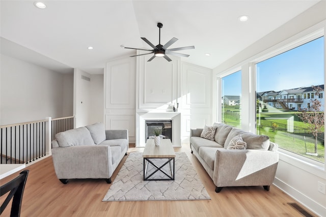 living room with vaulted ceiling, light hardwood / wood-style flooring, and ceiling fan