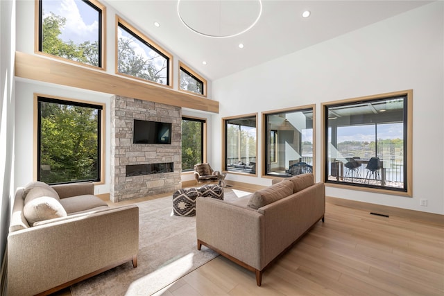 living room featuring light hardwood / wood-style floors, high vaulted ceiling, and plenty of natural light