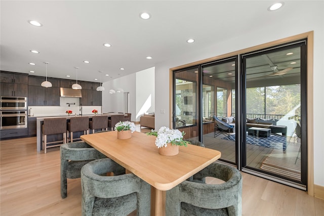 dining space with light hardwood / wood-style floors and sink