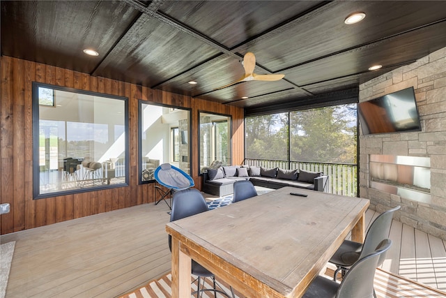 sunroom with ceiling fan, a healthy amount of sunlight, and wooden ceiling