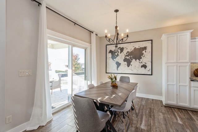 dining area with a notable chandelier and dark hardwood / wood-style flooring