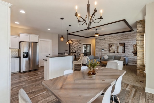 dining room featuring dark hardwood / wood-style floors and ceiling fan with notable chandelier