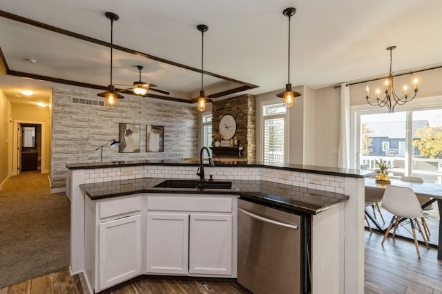 kitchen featuring white cabinets, dishwasher, dark wood-type flooring, pendant lighting, and sink