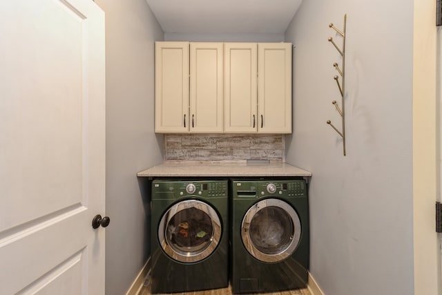 laundry room with washer and clothes dryer, hardwood / wood-style flooring, and cabinets