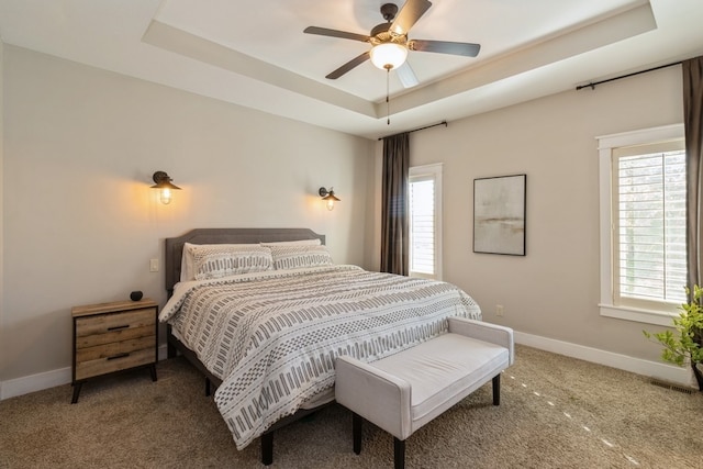 bedroom featuring ceiling fan, carpet flooring, and a raised ceiling