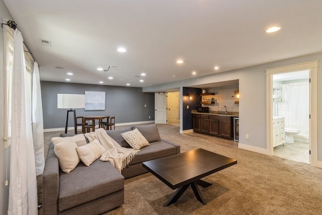 living room featuring indoor wet bar, wine cooler, and light colored carpet