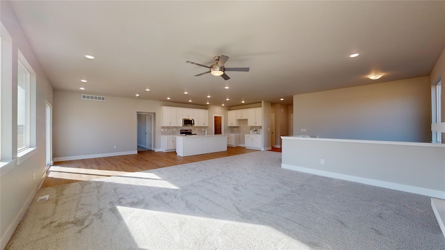 unfurnished living room featuring light hardwood / wood-style floors and ceiling fan