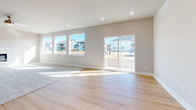 unfurnished living room featuring ceiling fan and light wood-type flooring