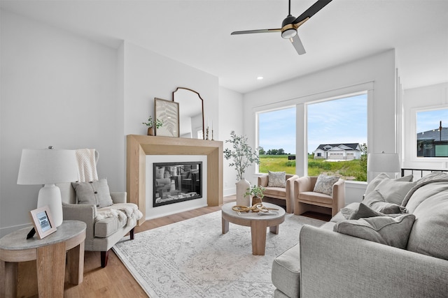 living room with ceiling fan, light hardwood / wood-style flooring, and plenty of natural light