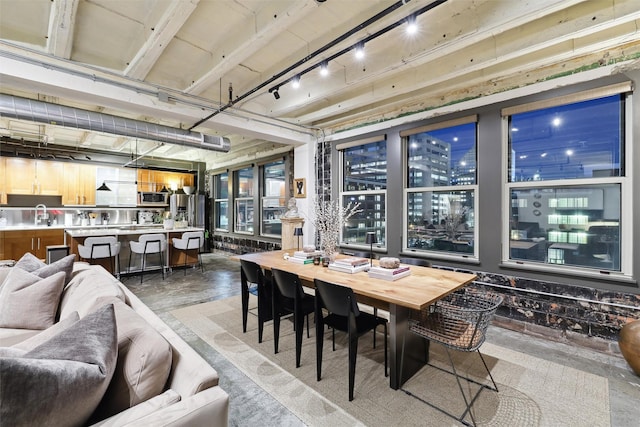 dining space with a view of city, concrete floors, and rail lighting