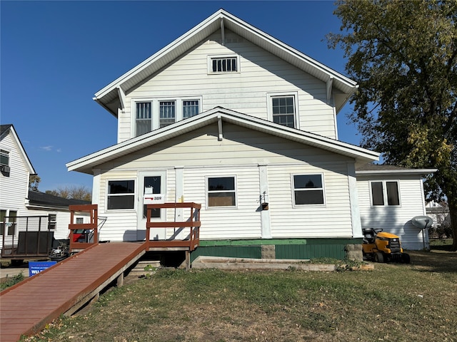 back of house featuring a wooden deck and a lawn