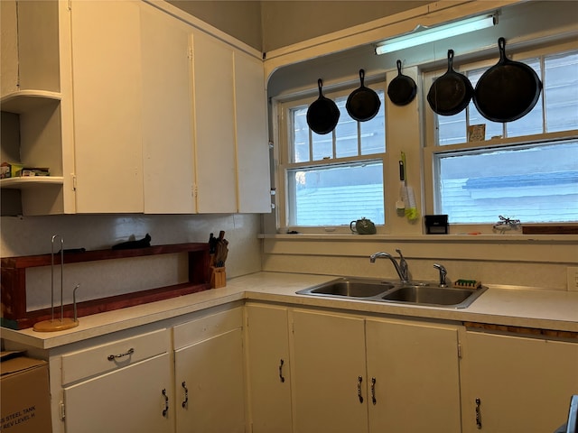 kitchen with sink, white cabinets, and a healthy amount of sunlight