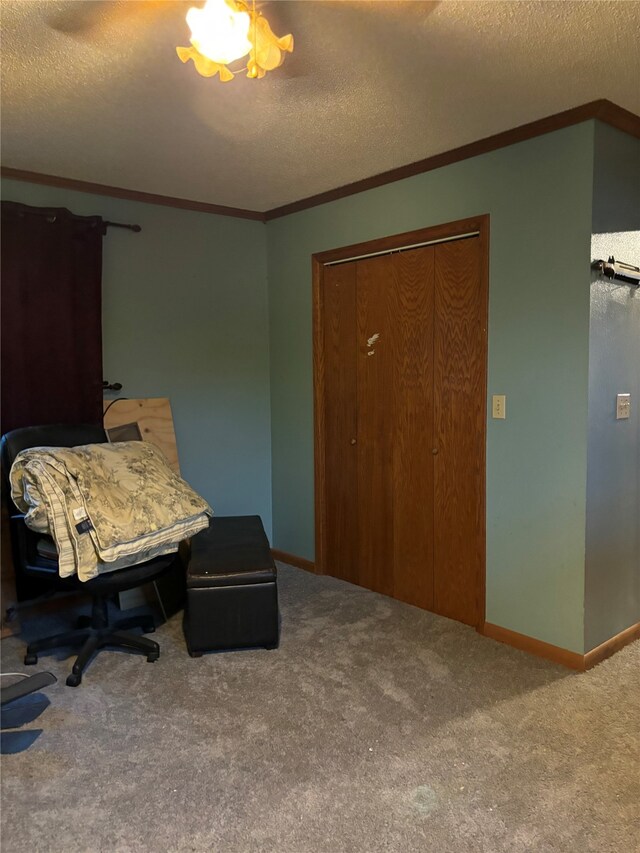 sitting room featuring ornamental molding, carpet, and a textured ceiling