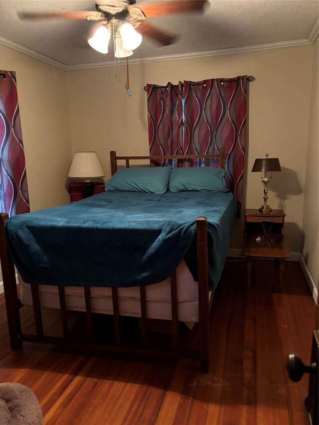 bedroom with ceiling fan, a textured ceiling, wood-type flooring, and ornamental molding