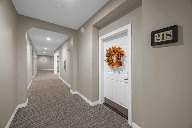 corridor featuring dark colored carpet