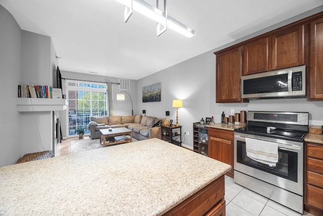 kitchen featuring light stone counters, stainless steel appliances, and light tile patterned floors