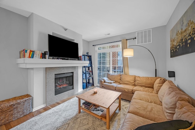 living room with light hardwood / wood-style floors and a tile fireplace