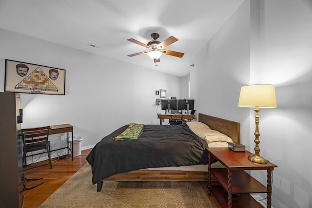 bedroom with hardwood / wood-style flooring, vaulted ceiling, and ceiling fan