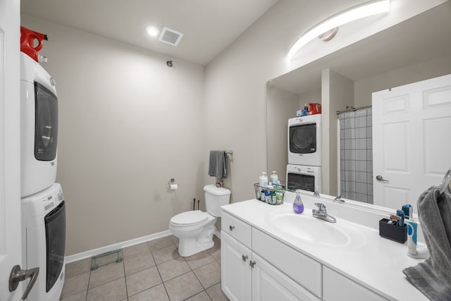 bathroom with toilet, stacked washer and clothes dryer, vanity, and tile patterned flooring