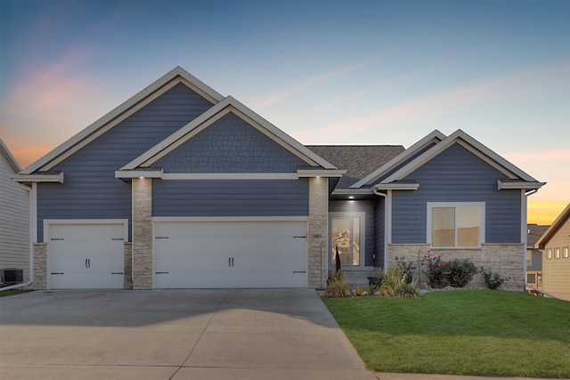 craftsman-style house featuring central AC unit, a garage, and a lawn