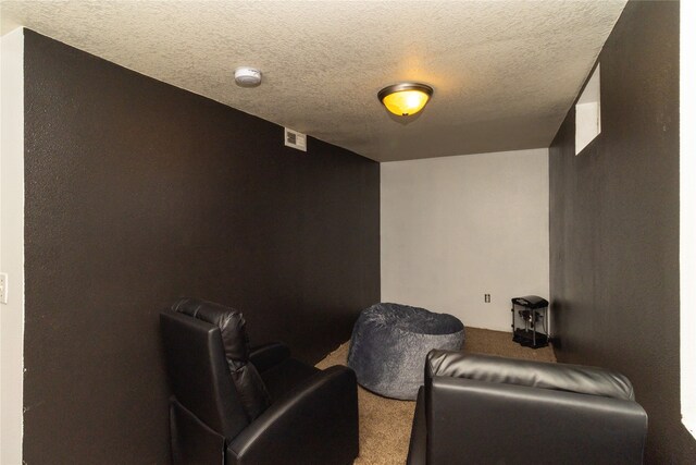 cinema featuring a textured ceiling and carpet flooring