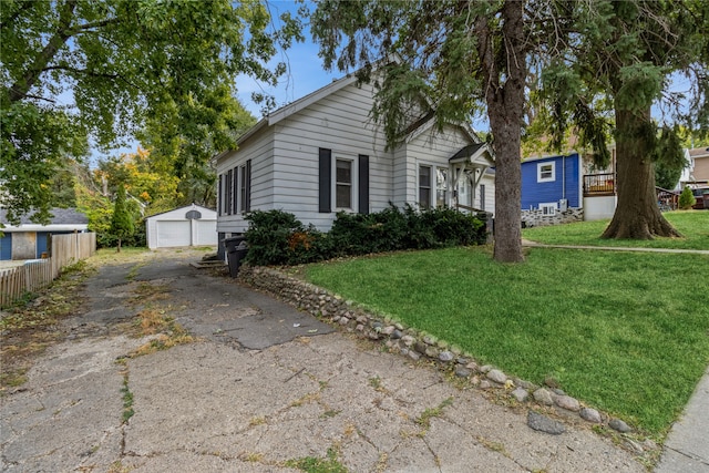 view of front of home featuring an outdoor structure, a front yard, and a garage