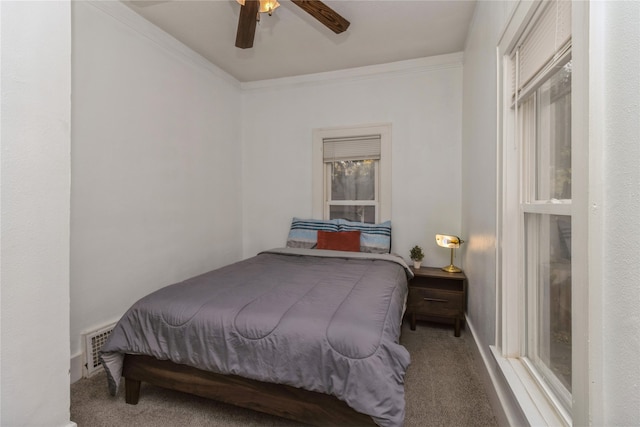 carpeted bedroom with ornamental molding and ceiling fan