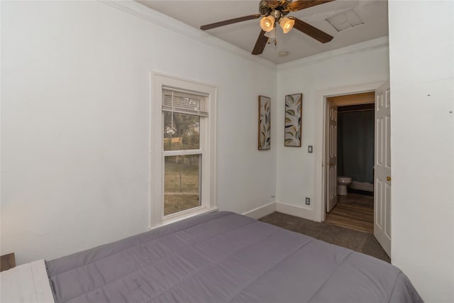 unfurnished bedroom featuring ensuite bath, ornamental molding, dark colored carpet, and ceiling fan