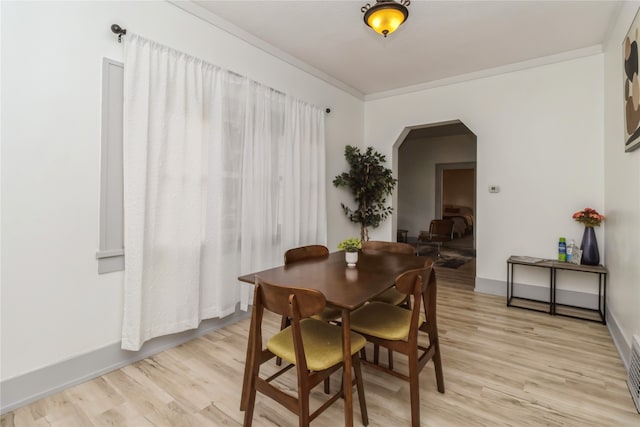 dining room with ornamental molding and light wood-type flooring