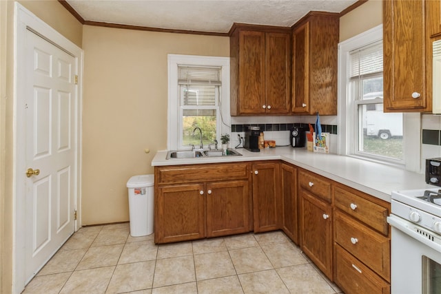 kitchen with ornamental molding, sink, backsplash, and light tile patterned floors