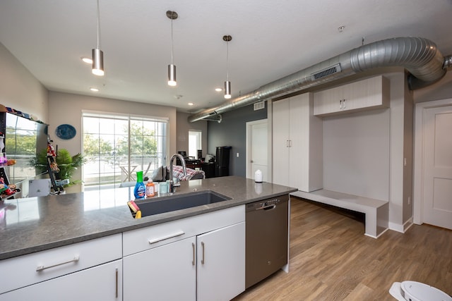 kitchen featuring sink, dishwasher, dark stone counters, decorative light fixtures, and white cabinets