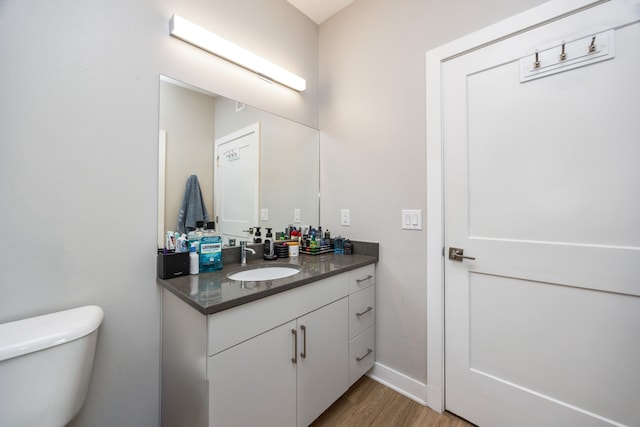 bathroom featuring vanity, toilet, and hardwood / wood-style floors