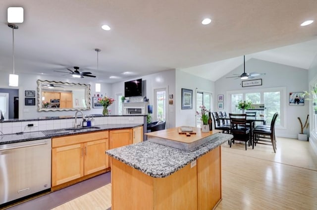 kitchen with lofted ceiling, dishwasher, sink, a center island, and decorative light fixtures