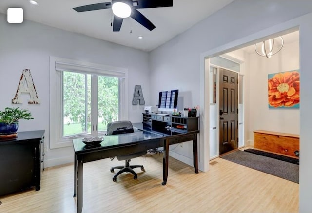 office space with light hardwood / wood-style flooring and ceiling fan with notable chandelier