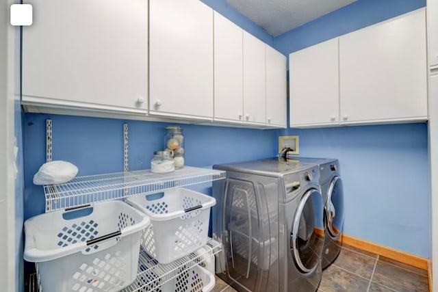 clothes washing area featuring washer and dryer and cabinets