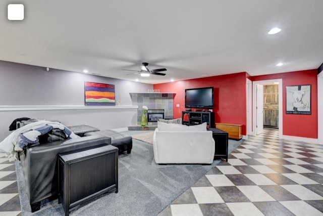 living room featuring a tiled fireplace and ceiling fan