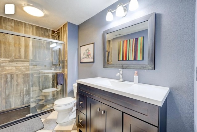 bathroom with toilet, walk in shower, vanity, and tile patterned floors