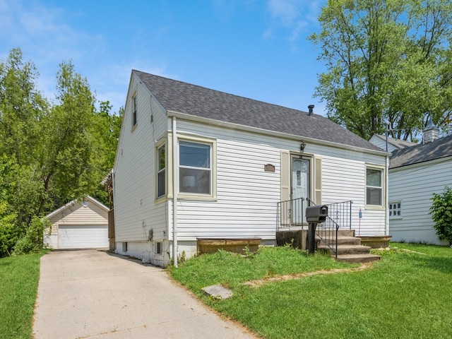 view of front of house with a front yard, an outbuilding, and a garage