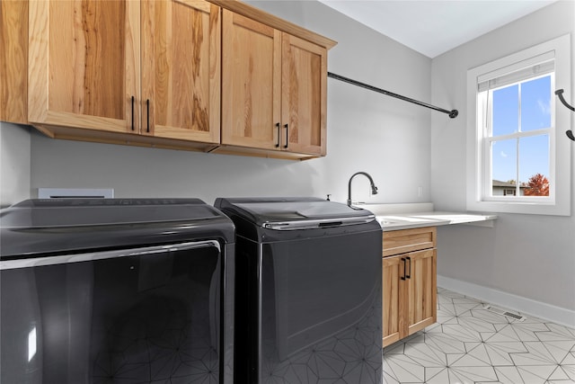 laundry area featuring light tile patterned flooring, cabinets, and separate washer and dryer