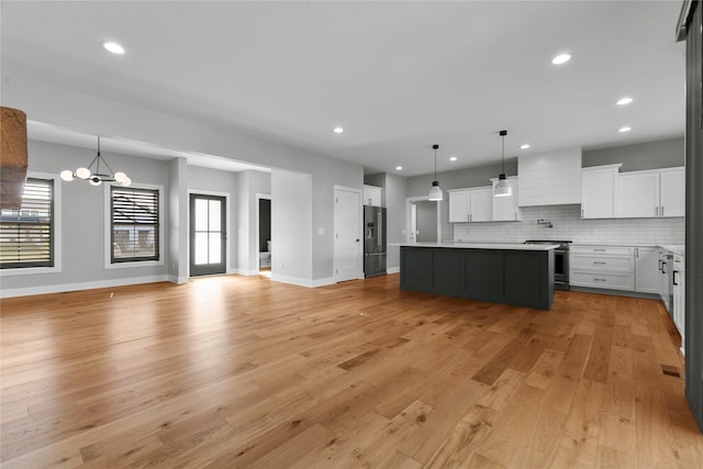 675 Daybreak Dr, Waukee, IA 50263 - kitchen with light wood-type flooring, stainless steel electric stove, a notable chandelier, open floor plan, and black fridge